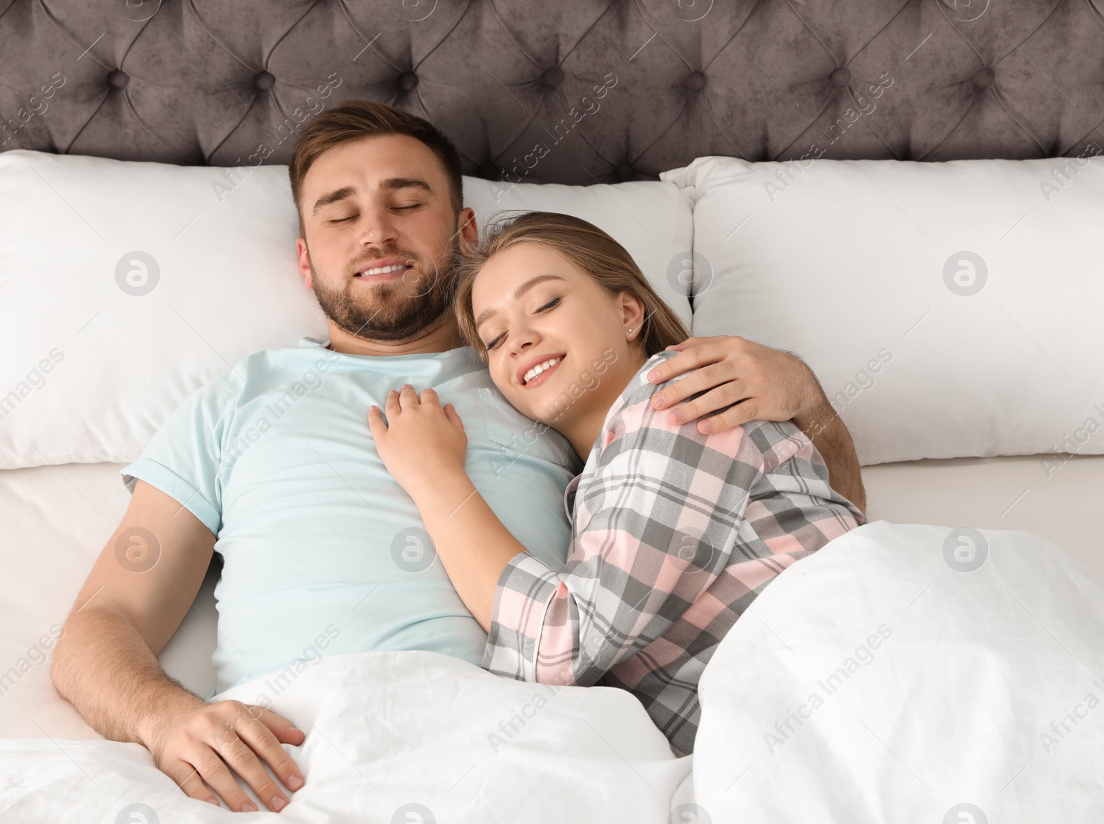 Photo of Young couple sleeping together in bed at home