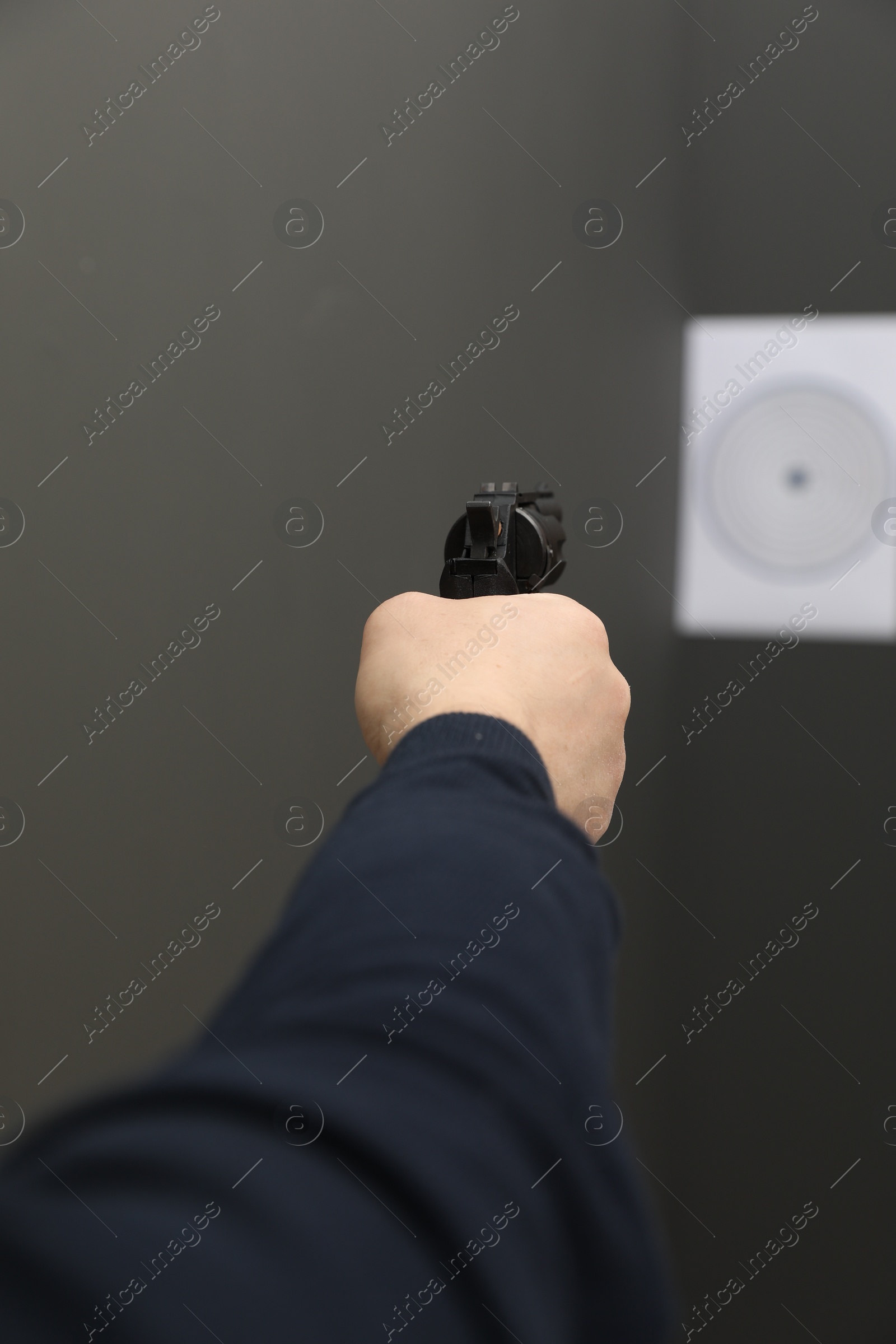 Photo of Man aiming at shooting target indoors, closeup