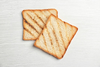 Toasted bread on light background, top view