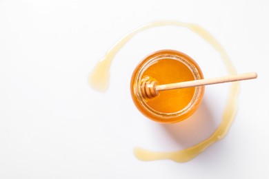 Photo of Jar with tasty natural honey and dipper on white background, top view