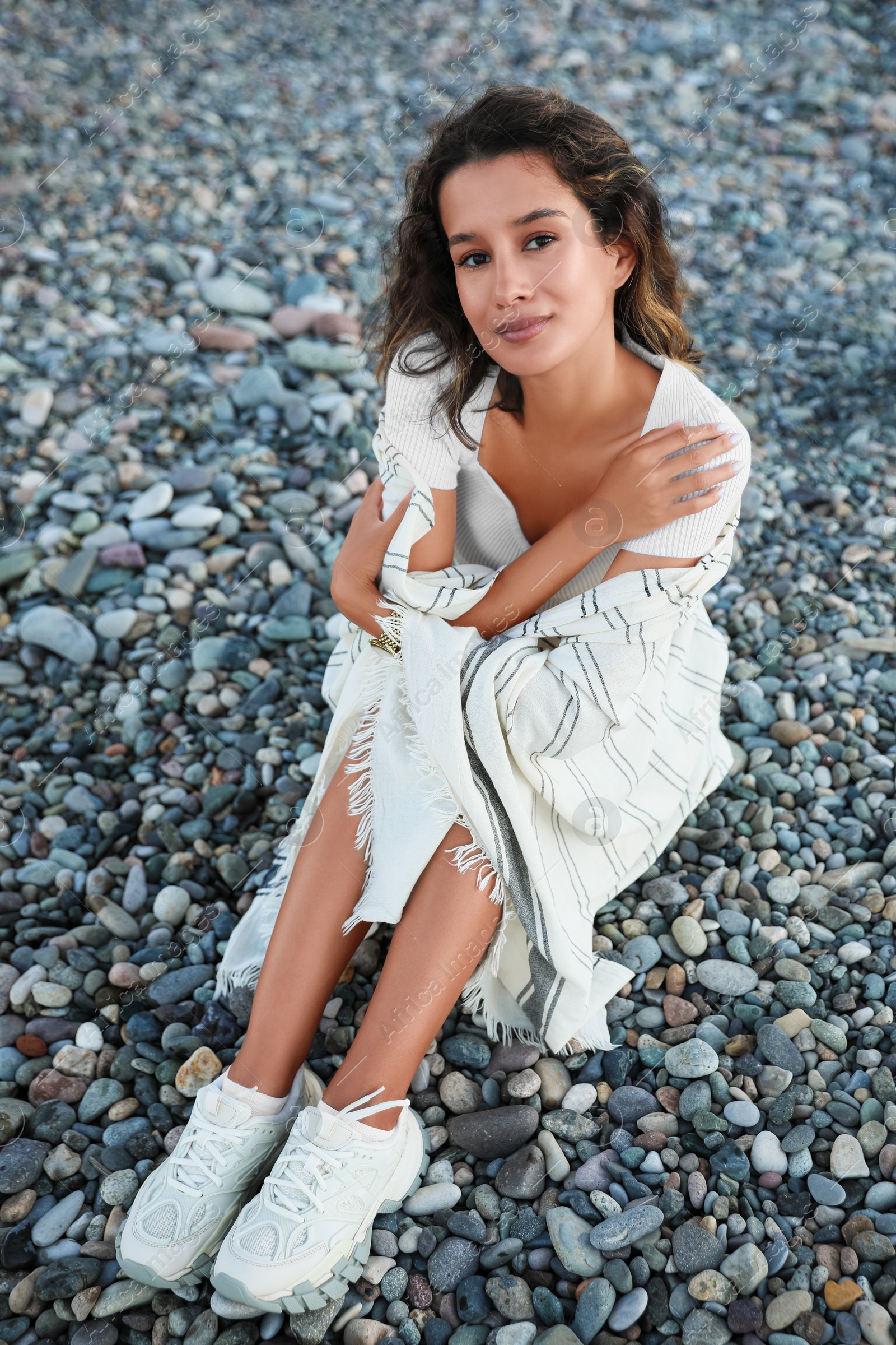 Photo of Portrait of happy young woman on pebble beach