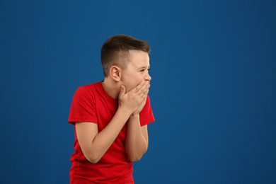 Photo of Portrait of laughing preteen boy on blue background, space for text