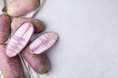 Purple daikon radishes on light grey table, flat lay. Space for text