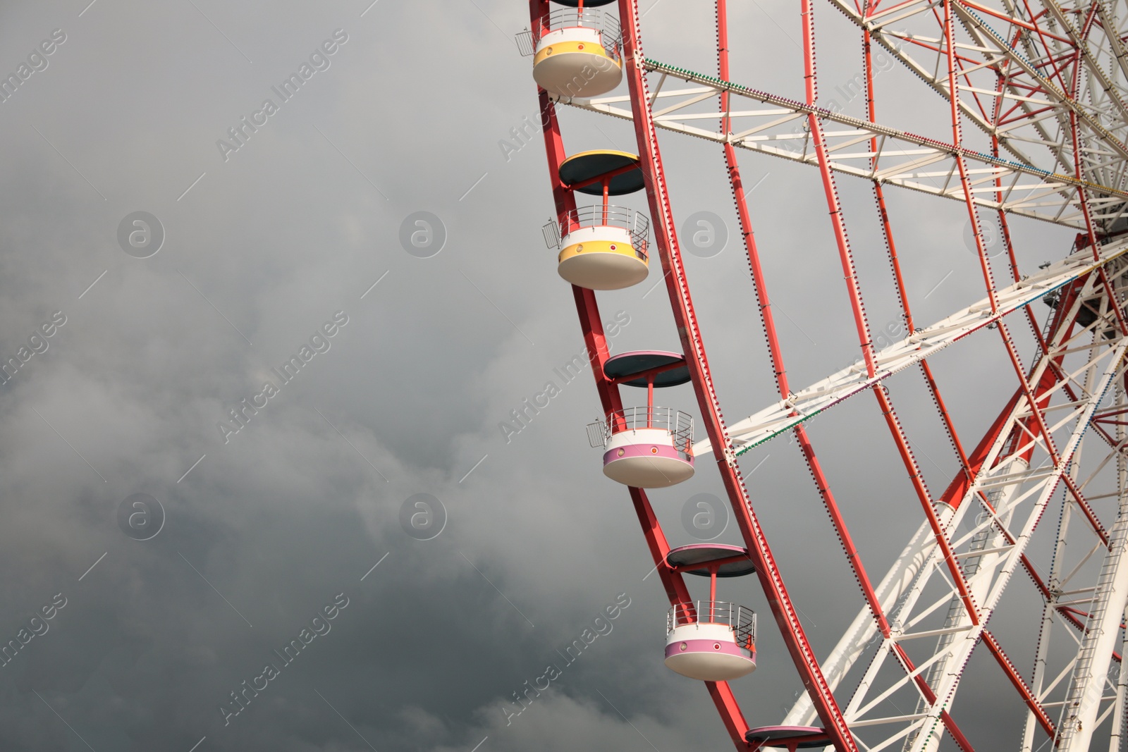 Photo of Beautiful large Ferris wheel against heavy rainy clouds outdoors. Space for text