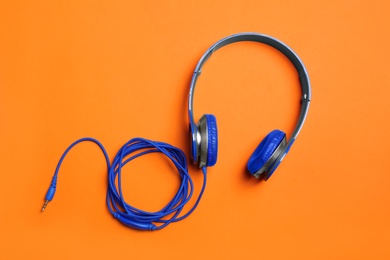 Stylish headphones on color background, top view