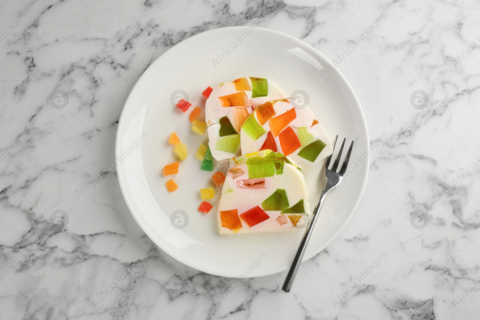 Photo of Delicious broken glass jelly dessert on white marble table, top view