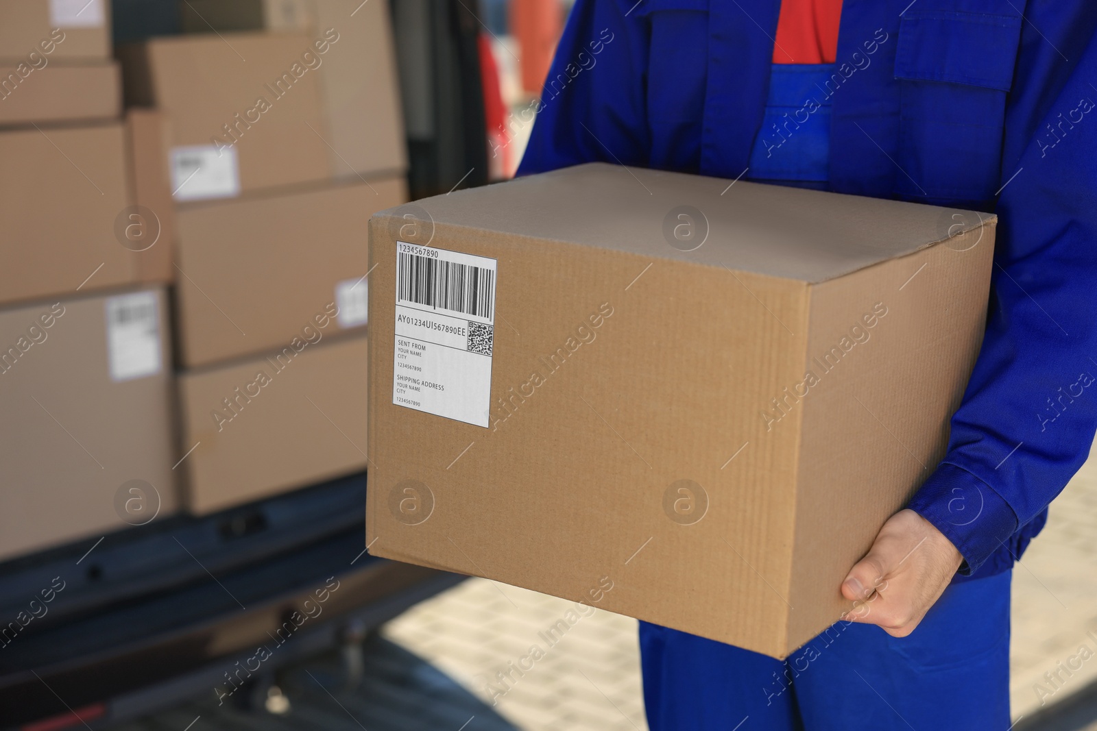 Photo of Courier with parcel near delivery van outdoors, closeup. Space for text