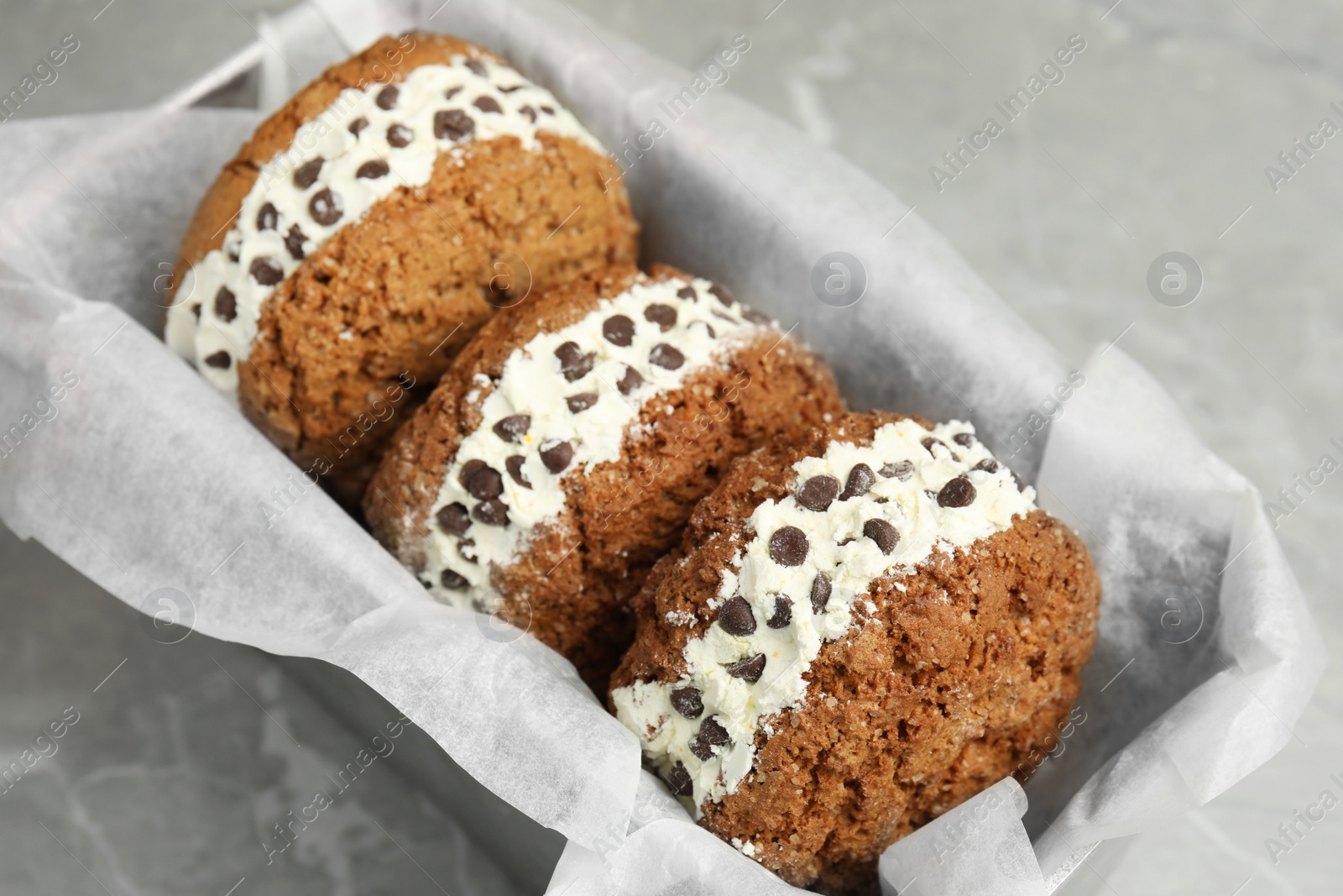 Photo of Sweet delicious ice cream cookie sandwiches with chocolate chips served on table