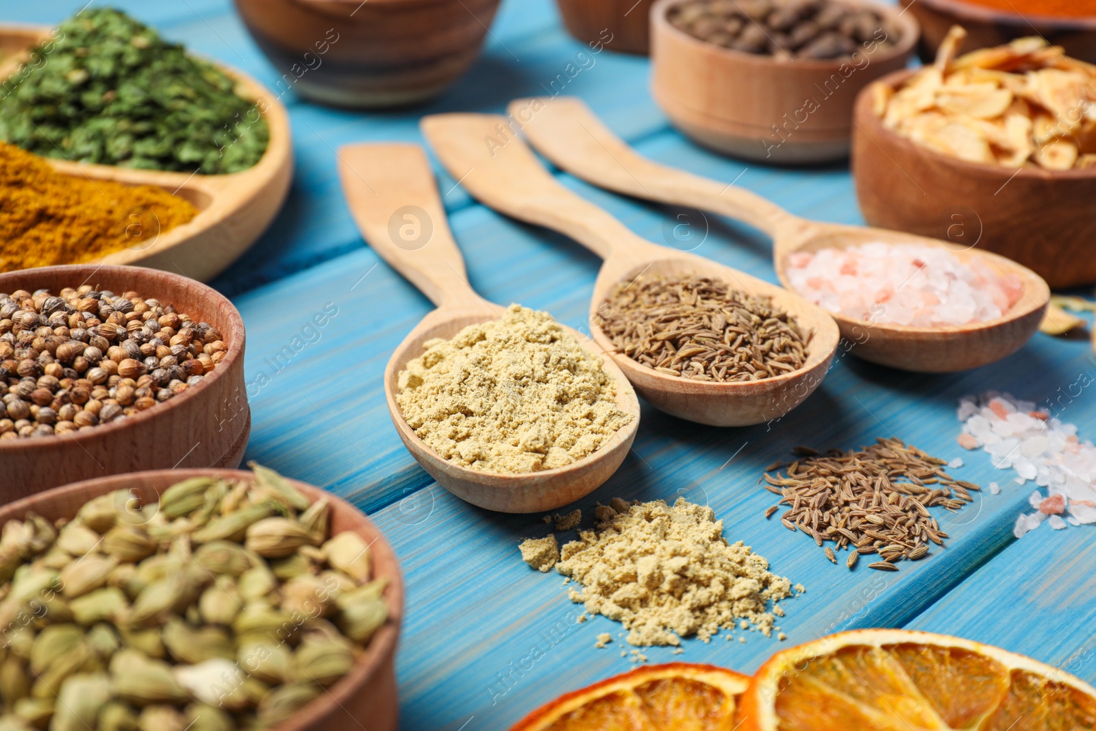 Photo of Many different spices on light blue wooden table
