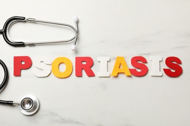 Photo of Word Psoriasis made of paper letters and stethoscope on white marble table, flat lay