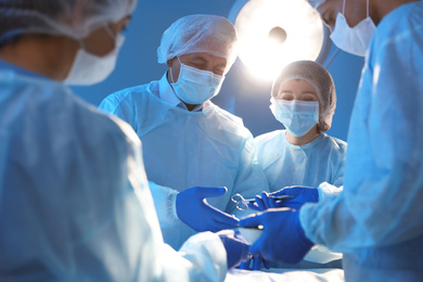 Team of professional doctors performing operation in surgery room