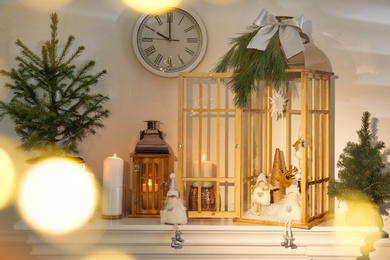 Photo of Christmas lanterns and other decorations on mantelpiece in room
