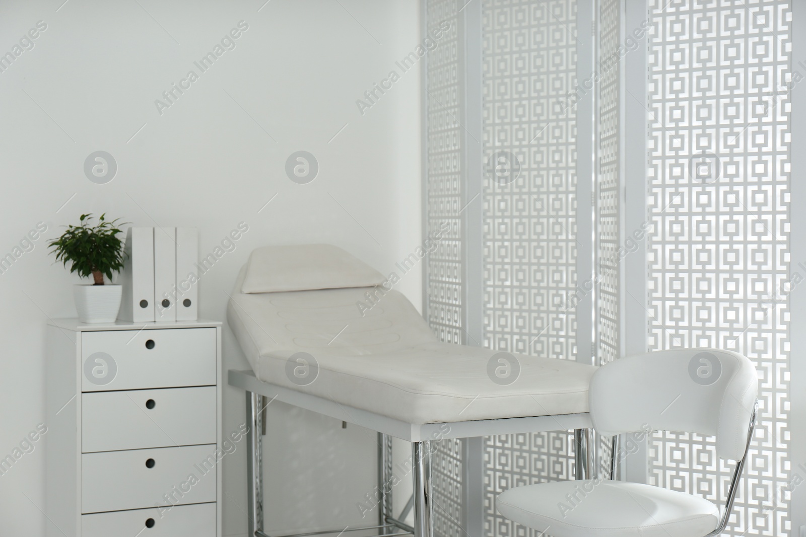 Photo of Examination room with modern couch and folding screen in clinic