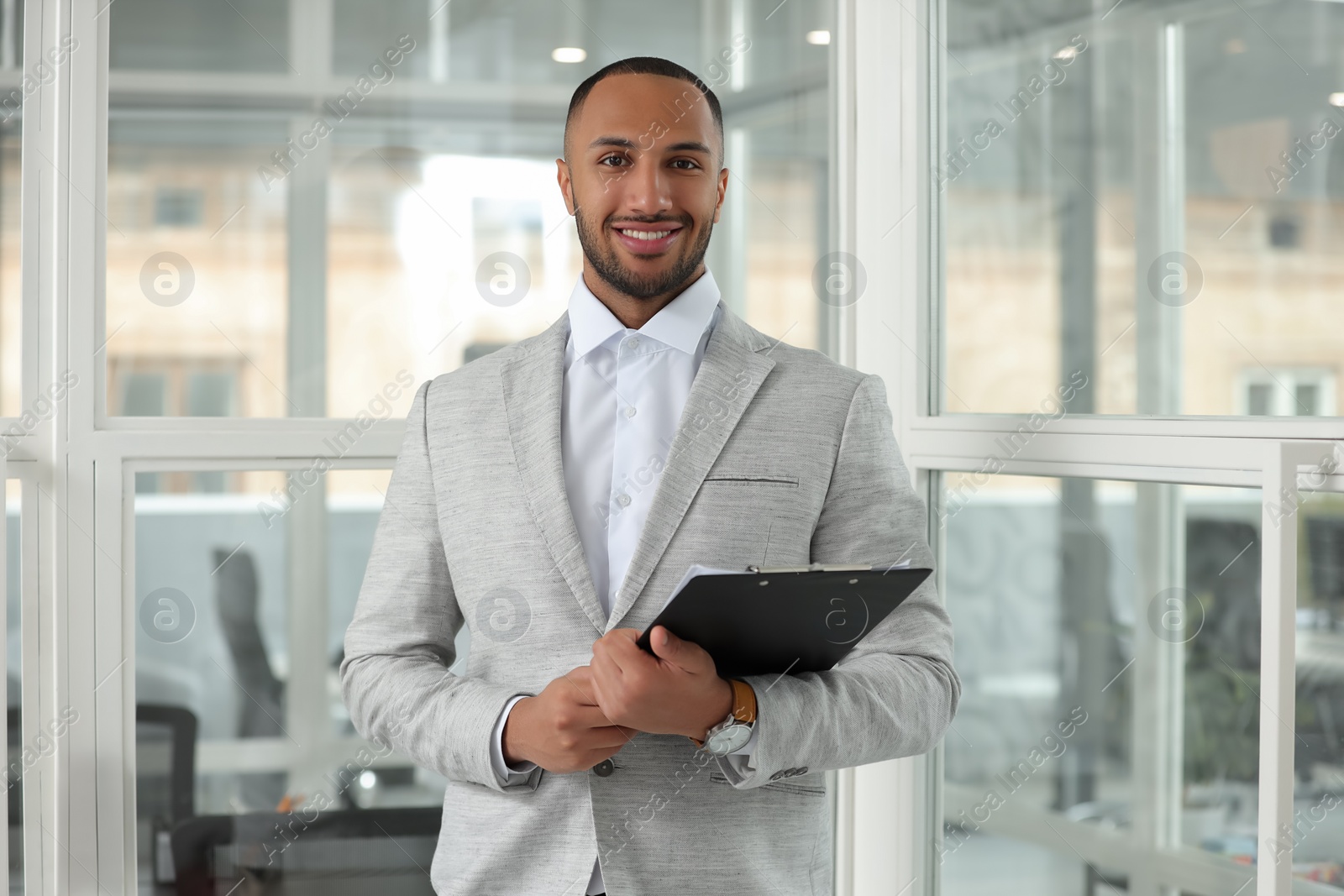 Photo of Happy man with clipboard in office. Lawyer, businessman, accountant or manager