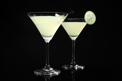 Photo of Glasses of delicious cucumber martini on dark background