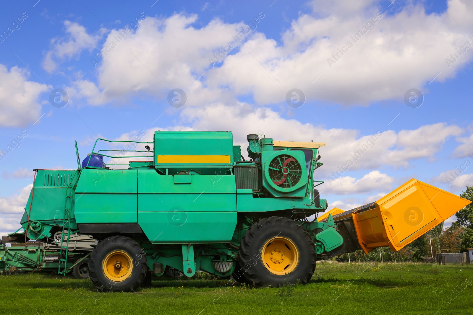 Photo of Modern combine harvester on green lawn with fresh grass