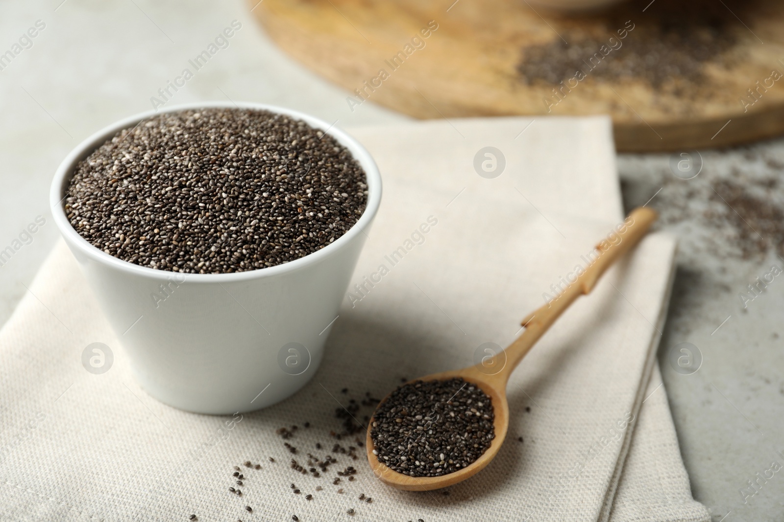 Photo of Chia seeds in bowl and spoon on table. Space for text