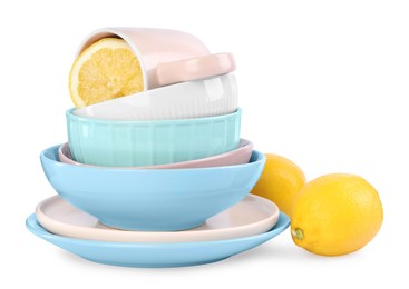 Stack of beautiful tableware and lemons on white background
