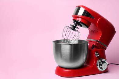 Photo of Modern red stand mixer on pink background, space for text