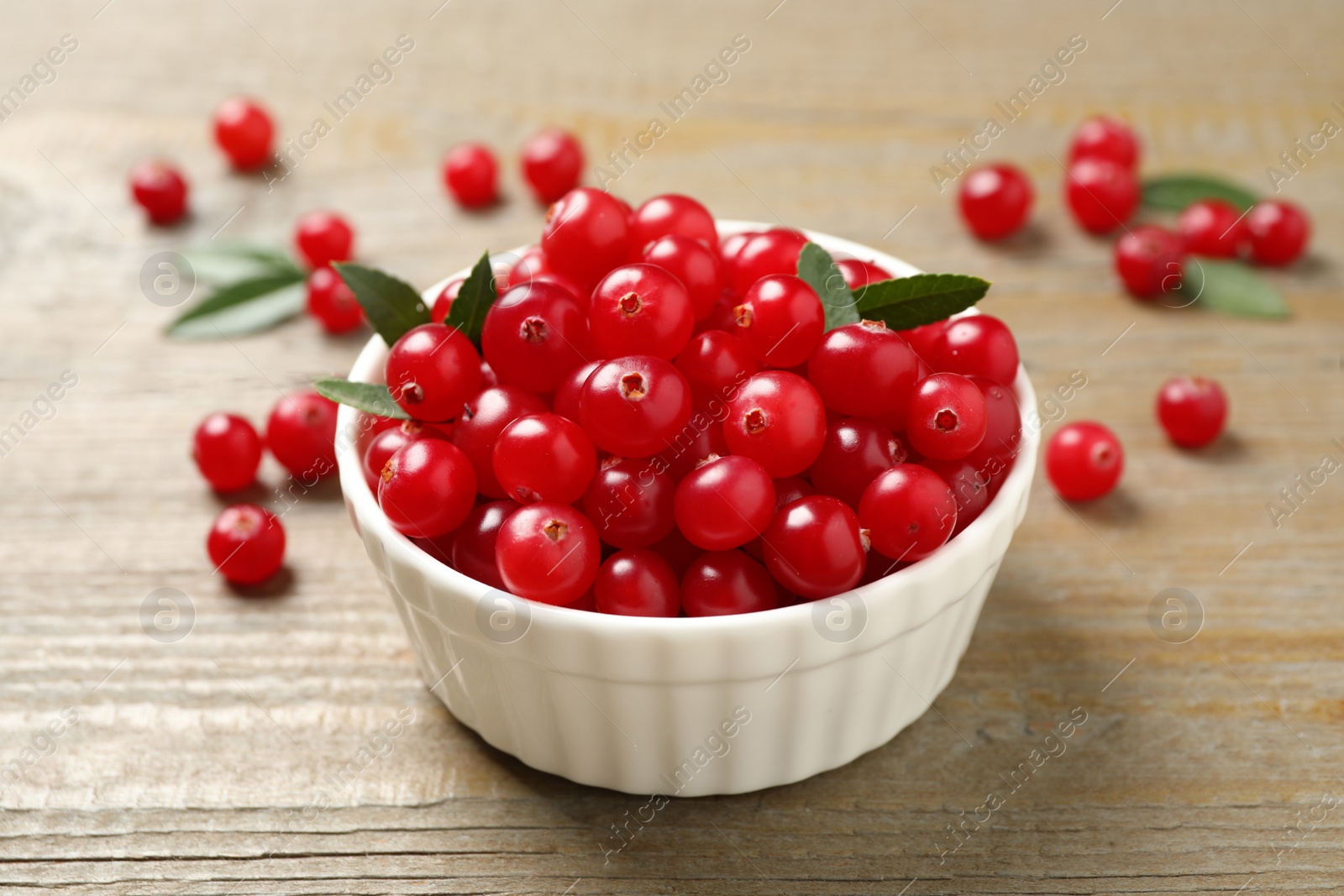 Photo of Tasty ripe cranberries on wooden table, closeup