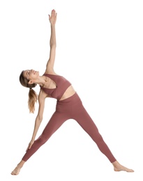 Young woman in sportswear practicing yoga on white background