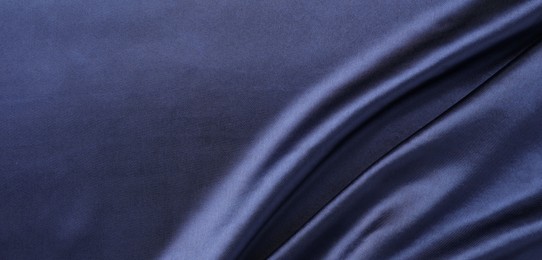 Photo of Crumpled dark blue silk fabric as background, top view. Space for text