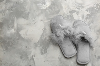 Pair of stylish soft slippers on grey background, flat lay. Space for text