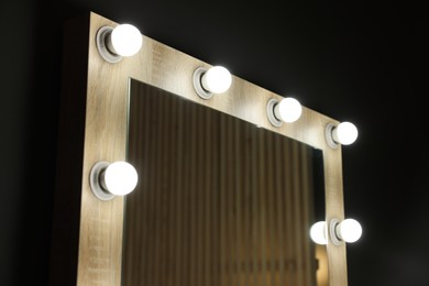 Beautiful mirror with light bulbs in makeup room, closeup