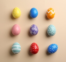 Photo of Flat lay composition of painted Easter eggs on color background