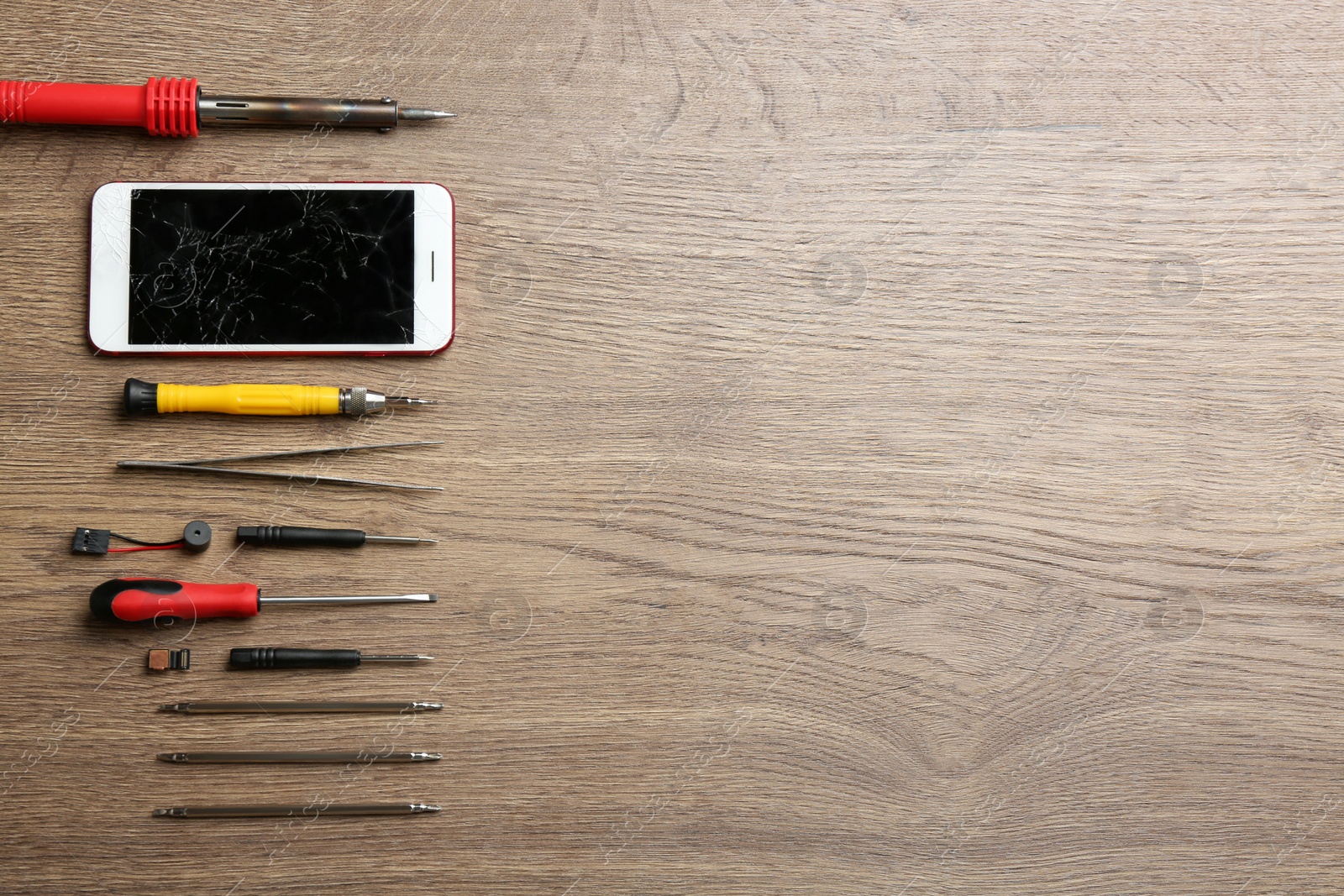 Photo of Broken mobile phone and repair tools on wooden table, flat lay. Space for text