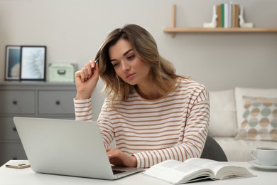 Online test. Woman studying with laptop at home