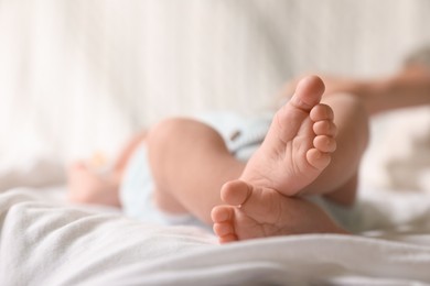 Photo of Cute newborn baby lying on bed, closeup of legs. Space for text