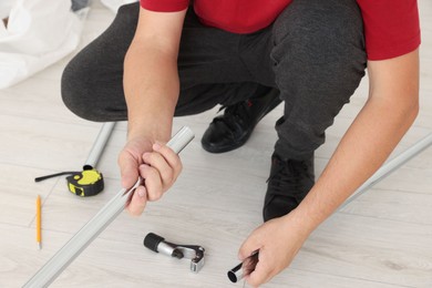 Worker installing new metal pipes indoors, closeup