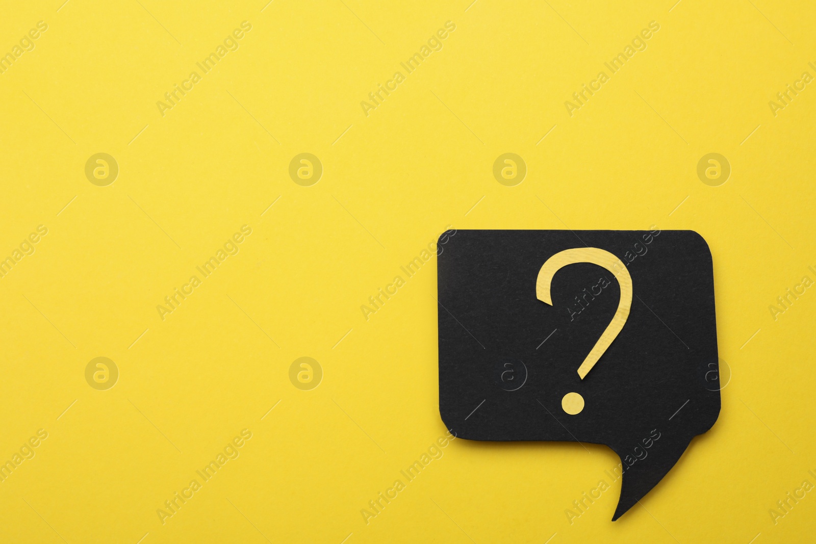 Photo of Paper speech bubble with question mark on yellow background, top view. Space for text