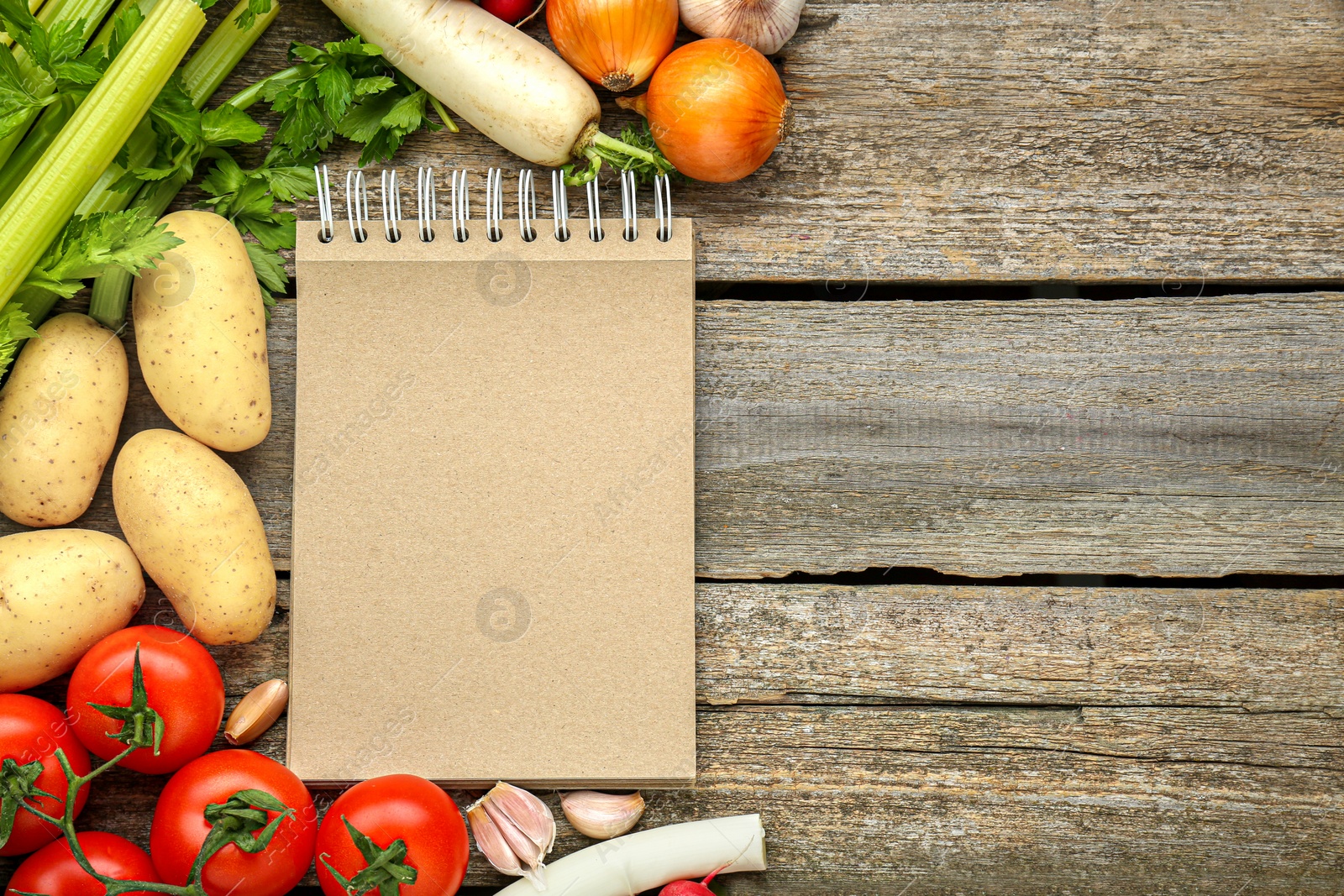 Photo of Blank recipe book and different ingredients on wooden table, flat lay. Space for text