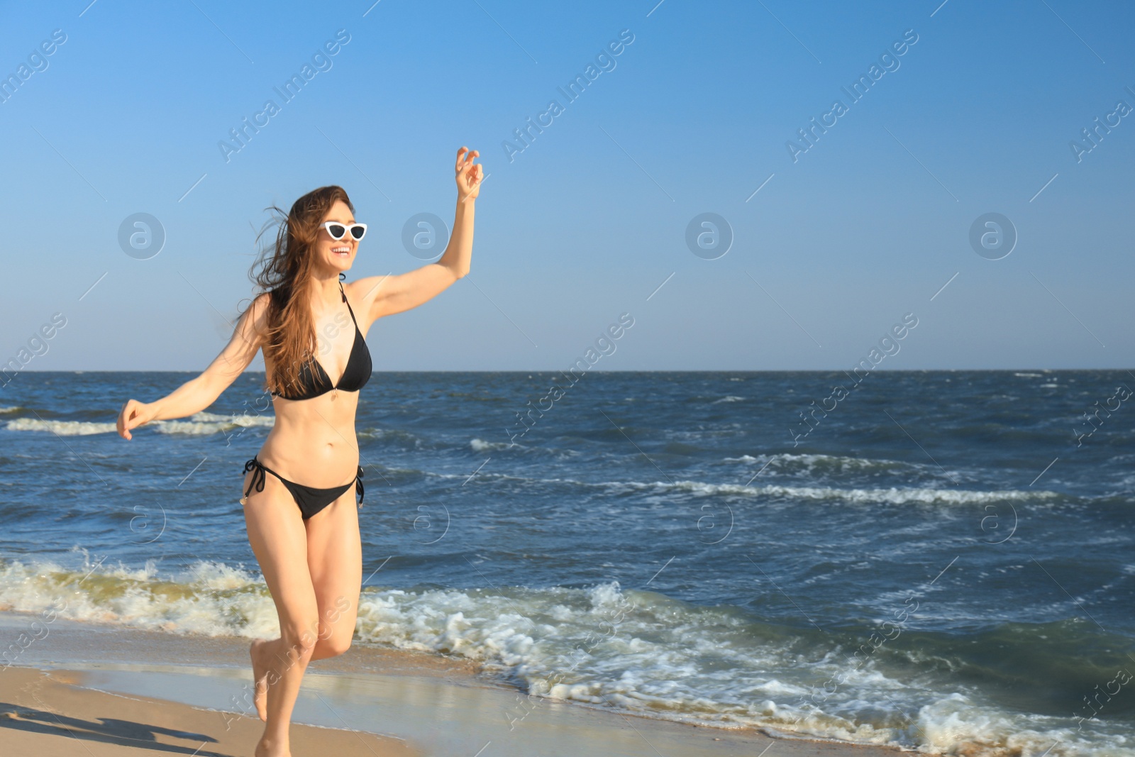 Photo of Beautiful woman in bikini on sea coast. Space for text