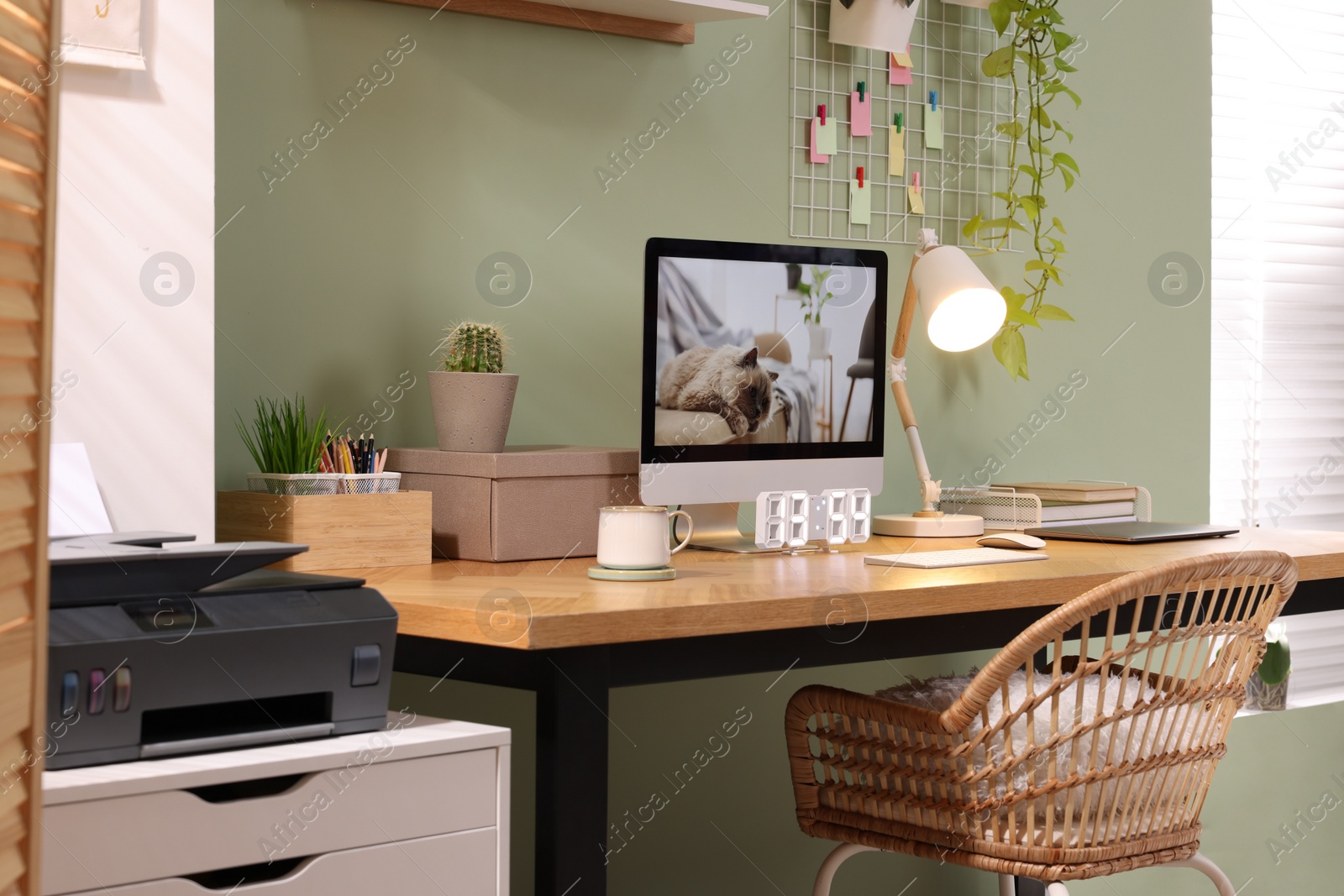 Photo of Stylish workplace with computer, laptop and lamp near olive wall at home