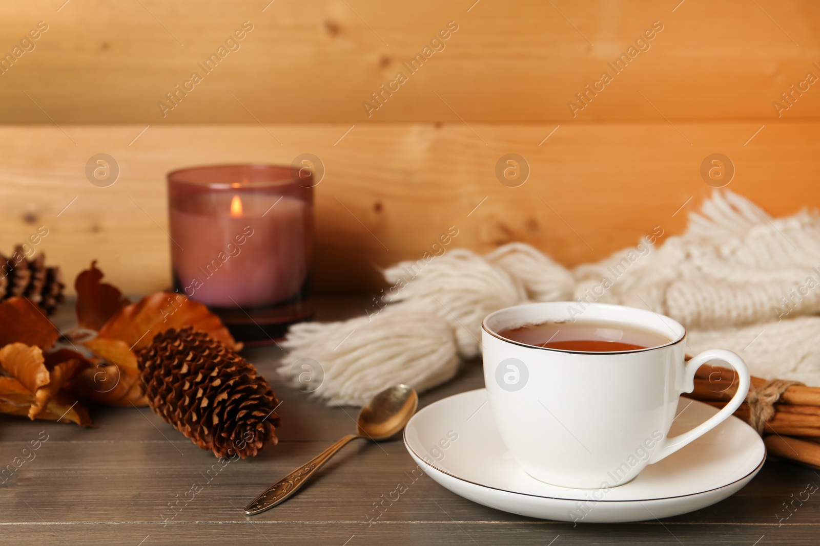 Photo of Composition with cup of hot tea and autumn leaves on wooden table, space for text