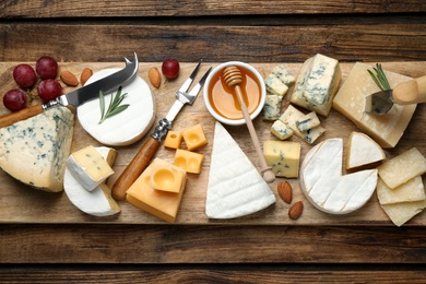 Photo of Flat lay composition with different sortscheese and knives on wooden table
