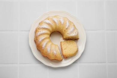 Photo of Delicious freshly baked sponge cake on white tiled table, top view