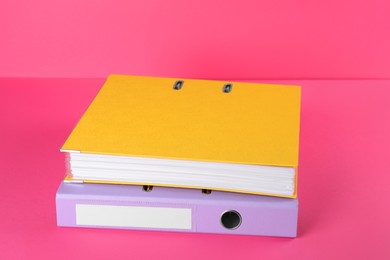 Photo of Bright hardcover office folders on pink background