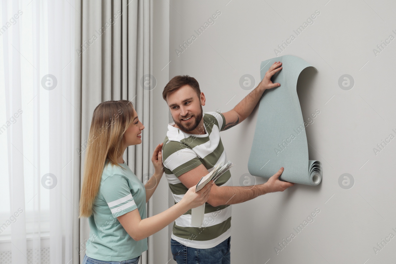 Photo of Young couple with new wall paper and color palette  indoors