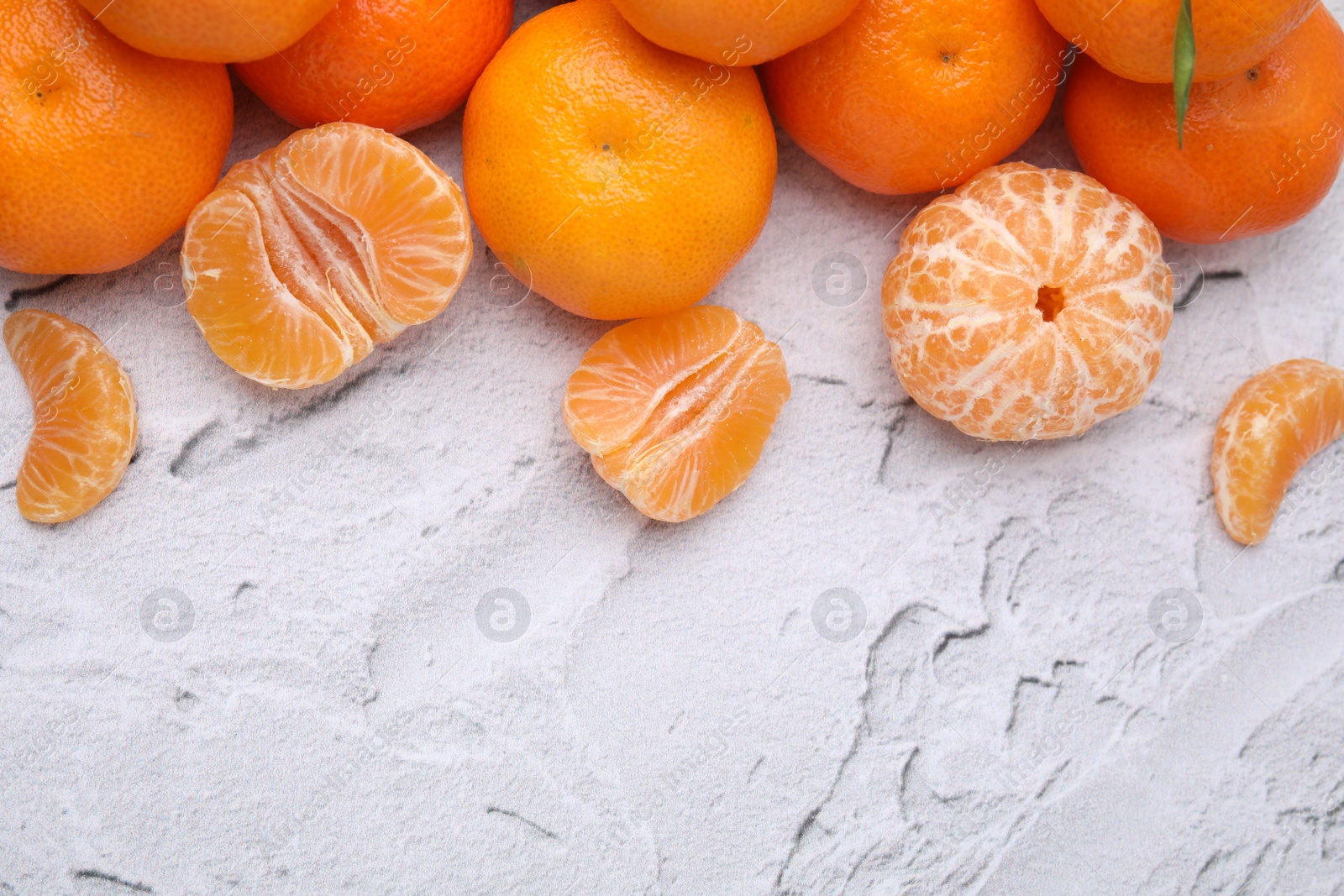 Photo of Fresh juicy tangerines on white textured table, flat lay. Space for text