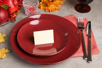 Photo of Beautiful autumn place setting with blank card and decor on grey table