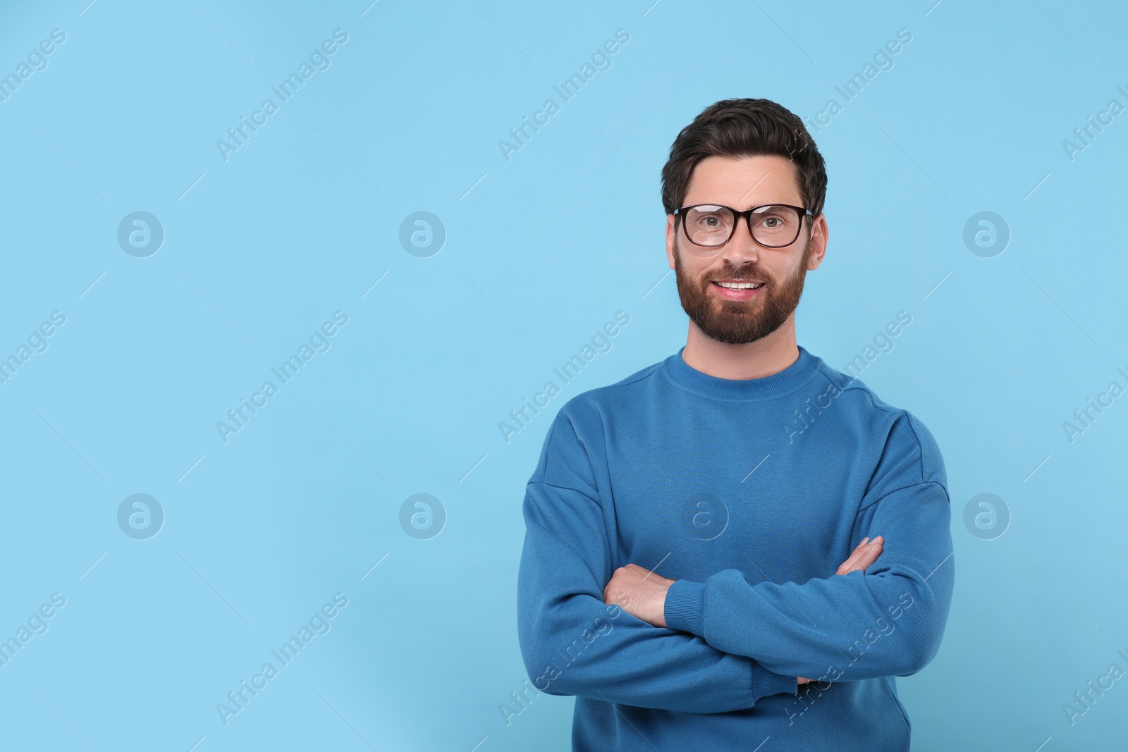 Photo of Portrait of handsome man in glasses on light blue background, space for text