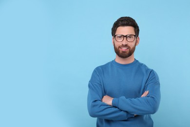 Photo of Portrait of handsome man in glasses on light blue background, space for text