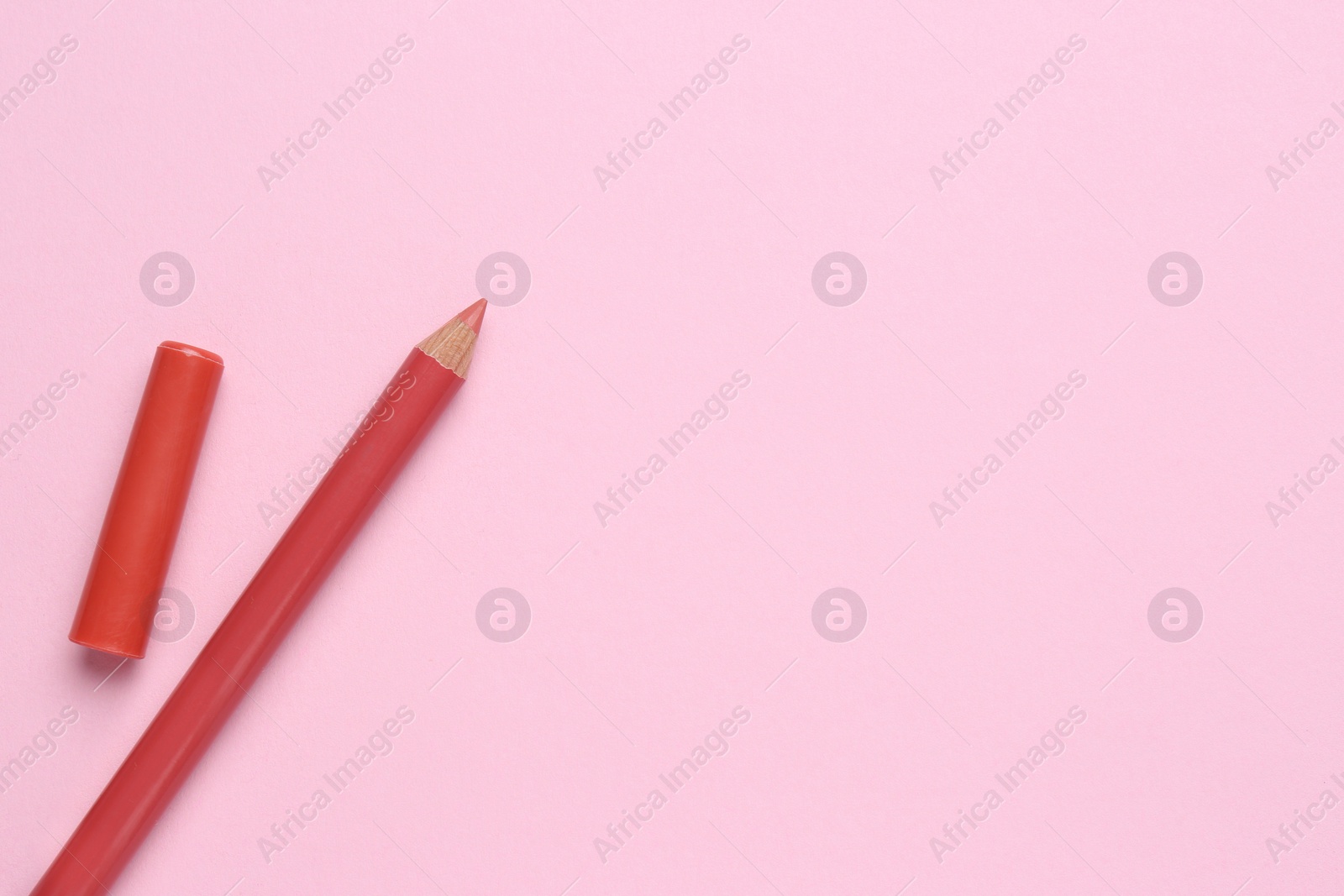 Photo of Lip pencil on pink background, flat lay with space for text. Cosmetic product