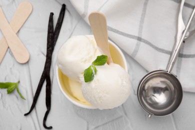 Photo of Delicious vanilla ice cream served on white textured table, flat lay