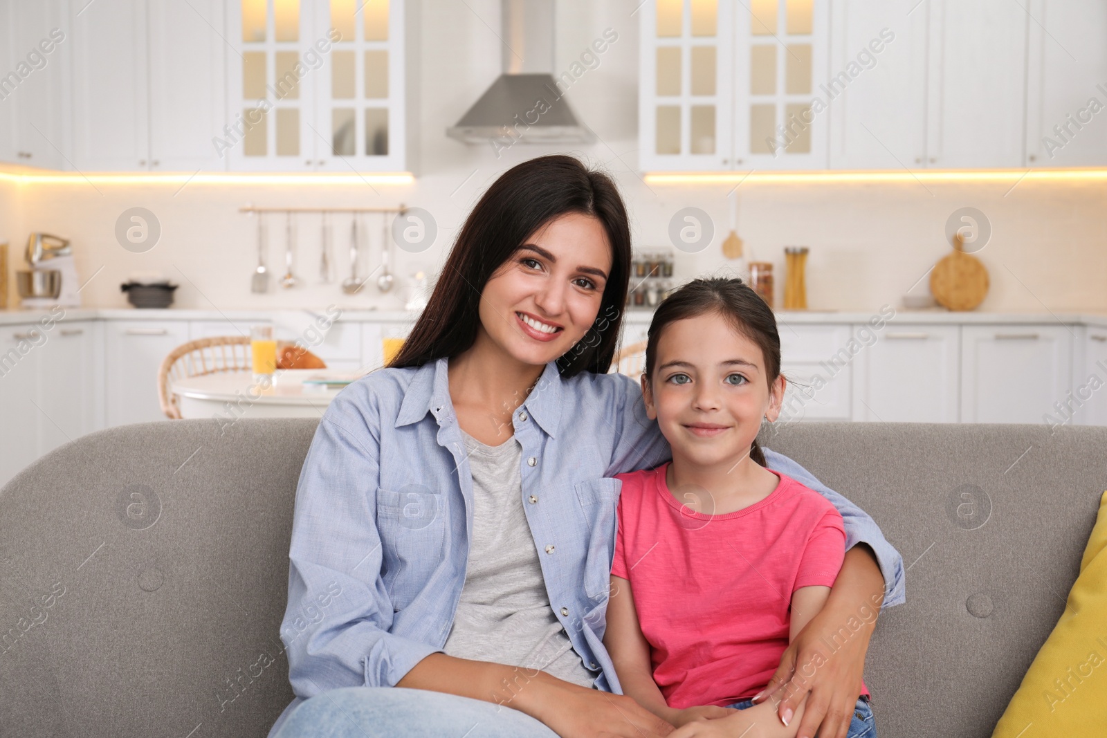 Photo of Portrait of happy mother and daughter on sofa at home. Single parenting