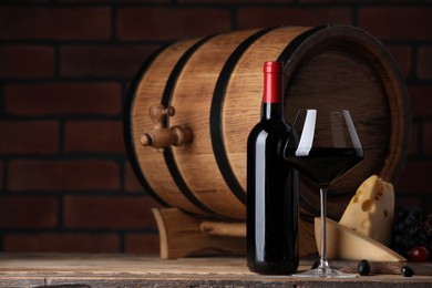 Delicious wine, cheese, grapes and wooden barrel on table against brick wall. Space for text
